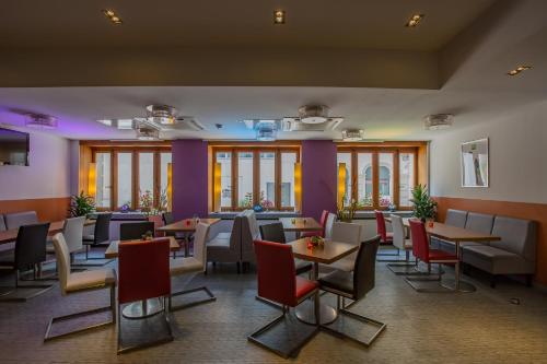 a restaurant with tables and chairs and windows at ibis Styles Luzern in Luzern