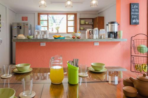 a kitchen with a wooden table with glasses of orange juice at La Bicicleta Hostal in Managua