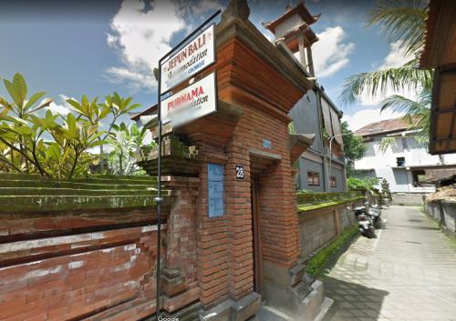 a brick building with a street sign on it at Jepun Bali Ubud Homestay in Ubud
