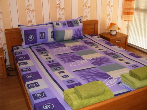 サニービーチにあるЕЛИТ 3 Апартаменти ELIT 3の大型ベッド(紫と灰色の掛け布団付)