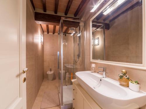 ein Badezimmer mit einem weißen Waschbecken und einer Dusche in der Unterkunft Casa Laura in San Gimignano