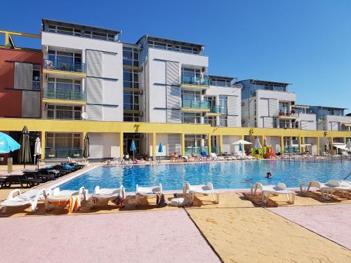 サニービーチにあるЕЛИТ 3 Апартаменти ELIT 3のラウンジチェアと建物のあるホテルのスイミングプールを提供しています。