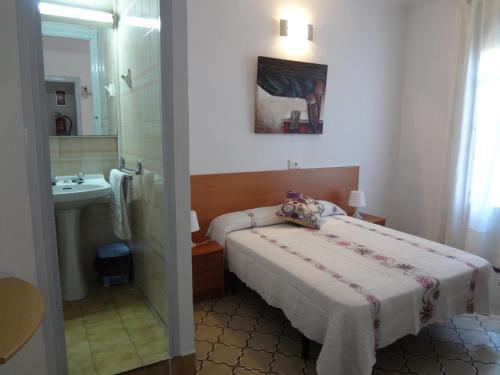 Dormitorio pequeño con cama y lavamanos en Hostal Sant Carlo, en Barcelona