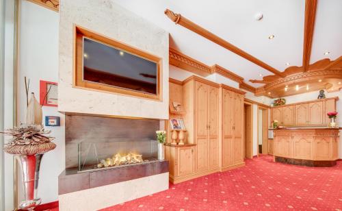 a large room with a fireplace and a flat screen tv at Hotel Albona in Ischgl