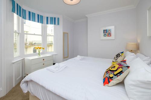 um quarto branco com uma cama branca e uma janela em Central Regency Town House em Brighton & Hove