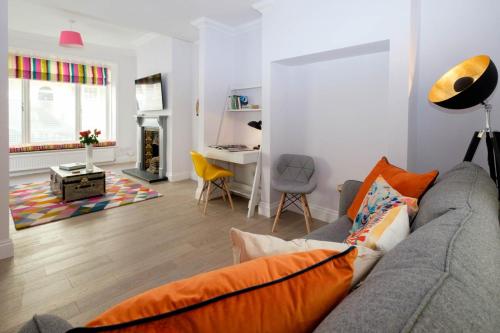 a living room with a gray couch and a desk at Central Regency Town House in Brighton & Hove