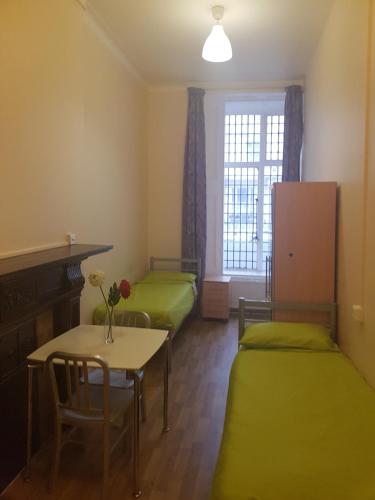 a room with two beds and a table and a window at Sandeman-Allen Hostel (Bayswater) in London