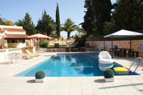 a swimming pool with a pool noodle in a backyard at Apartamentos - Solar Vale Covo in Carvoeiro