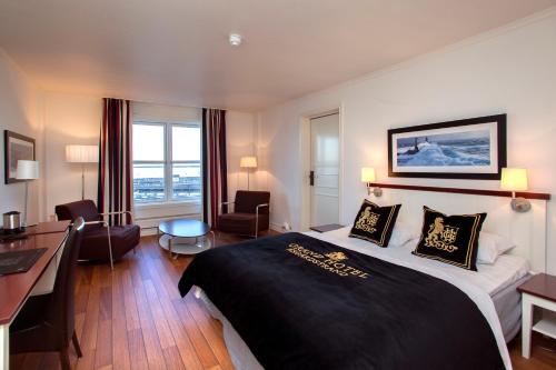 a hotel room with a large bed and a desk at Grand Hotel Åsgårdstrand - Unike Hoteller in Åsgårdstrand