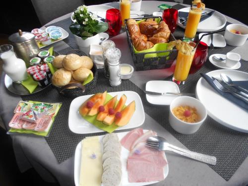 een tafel met borden eten op een tafel bij B&B Au Clair Obscur in Verviers