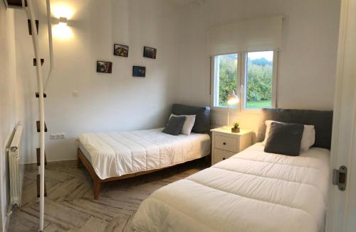 サンタマルタ・デ・オルティゲイラにあるCeltigos Beach Resortのベッドルーム1室(ベッド2台、窓付)