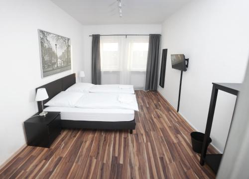 een slaapkamer met een bed en een houten vloer bij Bedroom in Neurenberg