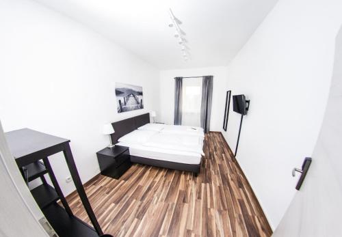 een kleine slaapkamer met een bed op een houten vloer bij Bedroom in Neurenberg