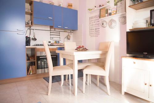 a kitchen with a table and chairs and a television at La Casa di Ortensia in Parma