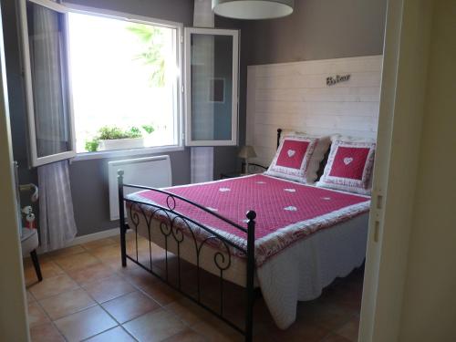 a bedroom with a bed with pink sheets and a window at Chambre Bel Air in Pimbo