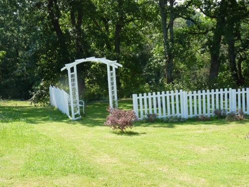 a white gate in a yard next to a white fence at Chambre Bel Air in Pimbo