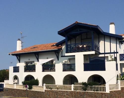 een wit gebouw met een balkon erboven bij Bel appartement vue mer - 1er rang front de mer in Saint-Jean-de-Luz