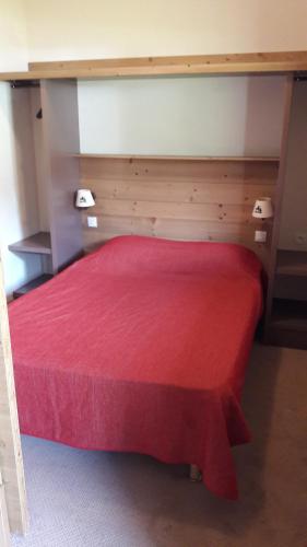 - une chambre avec un lit rouge et une couverture rouge dans l'établissement T2 RESIDENCE ANTARES 4* pieds des pistes, à Risoul