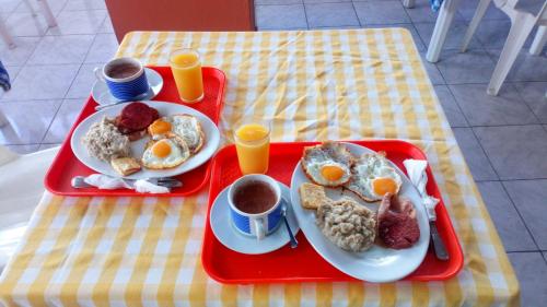 a tray with two plates of breakfast food on a table at Apartahotel Jardines Metropolitanos in Santiago de los Caballeros