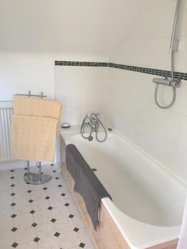 a bathroom with a white tub and a tiled floor at The Annexe, Upper Rooksnest in Inkpen