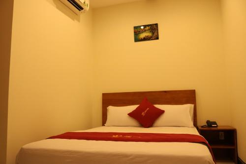 a bedroom with a bed with red and white pillows at Hoang Phuc Hotel in Thu Dau Mot