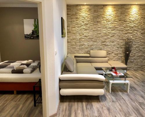 a living room with a couch and a bed at Wilsmann Apartmentvermietung in Hövelhof