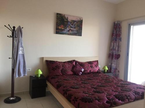 a bedroom with a red bed and a window at Ocean View BGB Resort in Bouznika