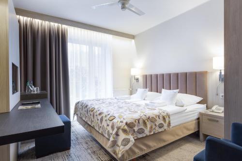 a hotel room with a bed and a window at Willa Spa Scaliano in Kudowa-Zdrój