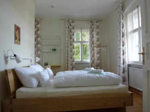 a bedroom with a bed with white sheets and a window at Villa Breitenberg in Breitenberg