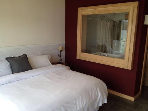 una camera con letto bianco e specchio di Correntoso TownHouses a Villa La Angostura
