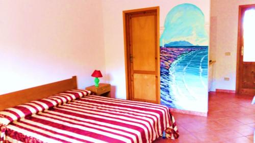 una camera da letto con un letto e un dipinto sul muro di Cala Rossa Dream a Favignana
