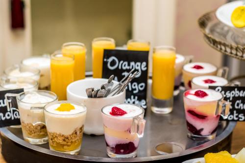 a tray filled with different types of desserts and orange juice at The Somerville in Torquay