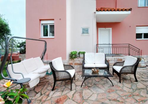 un patio con sillas, una mesa y un edificio en Villa Sunset, en Paralia Vrachou