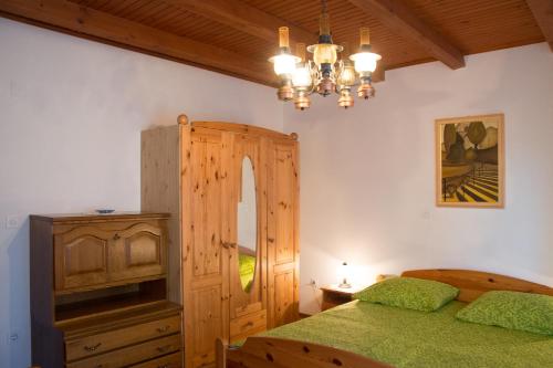 1 dormitorio con cama y lámpara de araña en Apartments Ivančič, en Kobarid