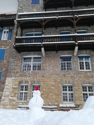 a snowman with a red hat in front of a building at Residence Grand Hotel Carezza in Nova Levante