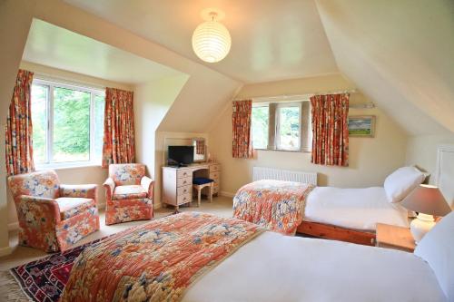 a hotel room with two beds and a chair at Oxbridge Farm in Netherbury