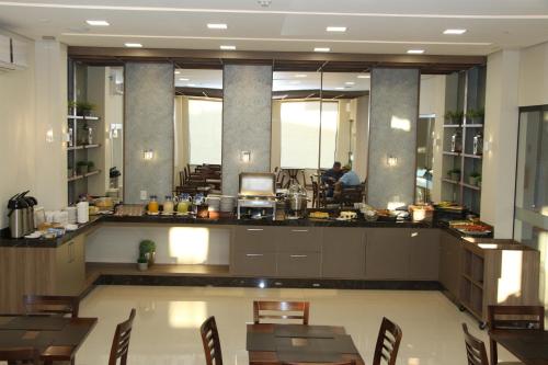 a dining room with tables and chairs in a building at Hotel B&S in Nova Andradina