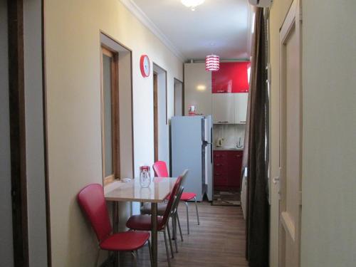 Una cocina con mesa y sillas y un refrigerador. en Apartment Avlabari (In old Tbilisi), en Tiflis