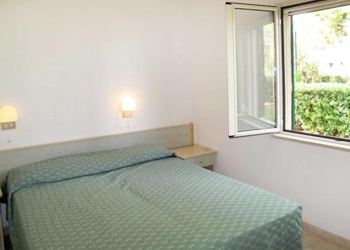 a bedroom with a bed and a window at Villaggio San Lorenzo in Vieste