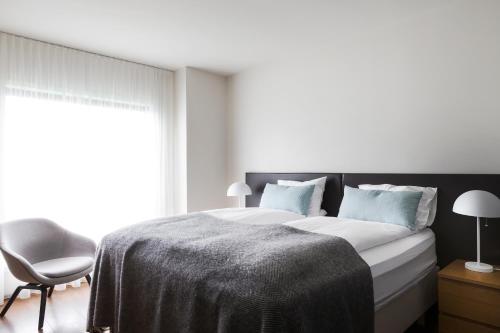a bed with a white comforter and pillows at Hotel Berg by Keflavik Airport in Keflavík