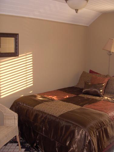 a bedroom with a bed and a chair and a window at Historic 1920s Cabin in Long Beach