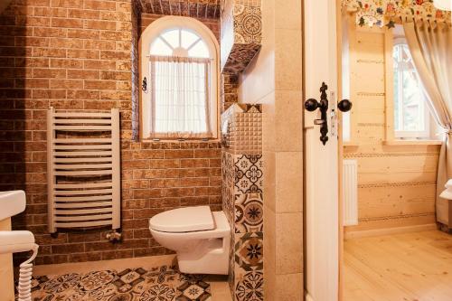 a brick bathroom with a toilet and a window at Gorce Oasis in Szlembark