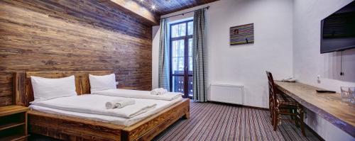 a bedroom with a bed with a wooden wall at Shpatser hotel in Briukhovychi