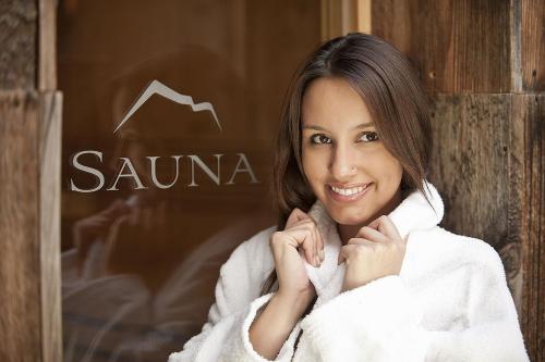 a woman wrapped in a towel in front of a sign at Appartements Kerschbaumer in Feldthurns