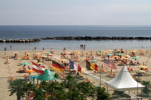 a beach filled with lots of people and umbrellas at Appartamenti Montmartre in Rimini