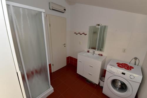 a bathroom with a washing machine and a washer at Bonaca in Rtina