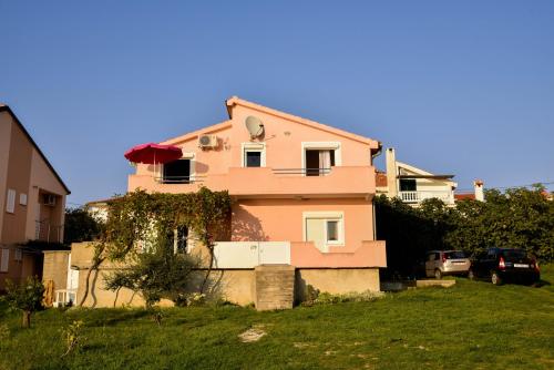 a pink house sitting on top of a green field at Bonaca in Rtina