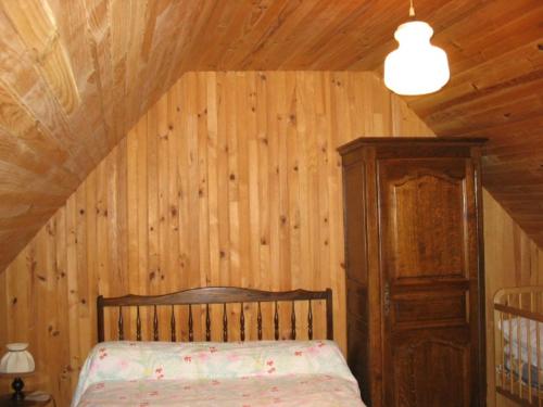 カマレ・シュル・メールにあるLe moign-locationsの木製の壁のベッドルーム1室(ベッド1台付)