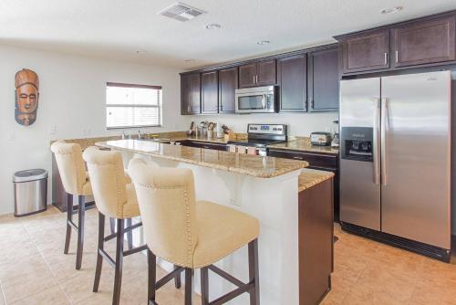 a kitchen with a large island with bar stools at Modern 4 bedroom House with swimming pool in Clearwater