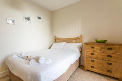 a bedroom with a bed and a dresser with towels on it at The Artane Self Catering in Dublin